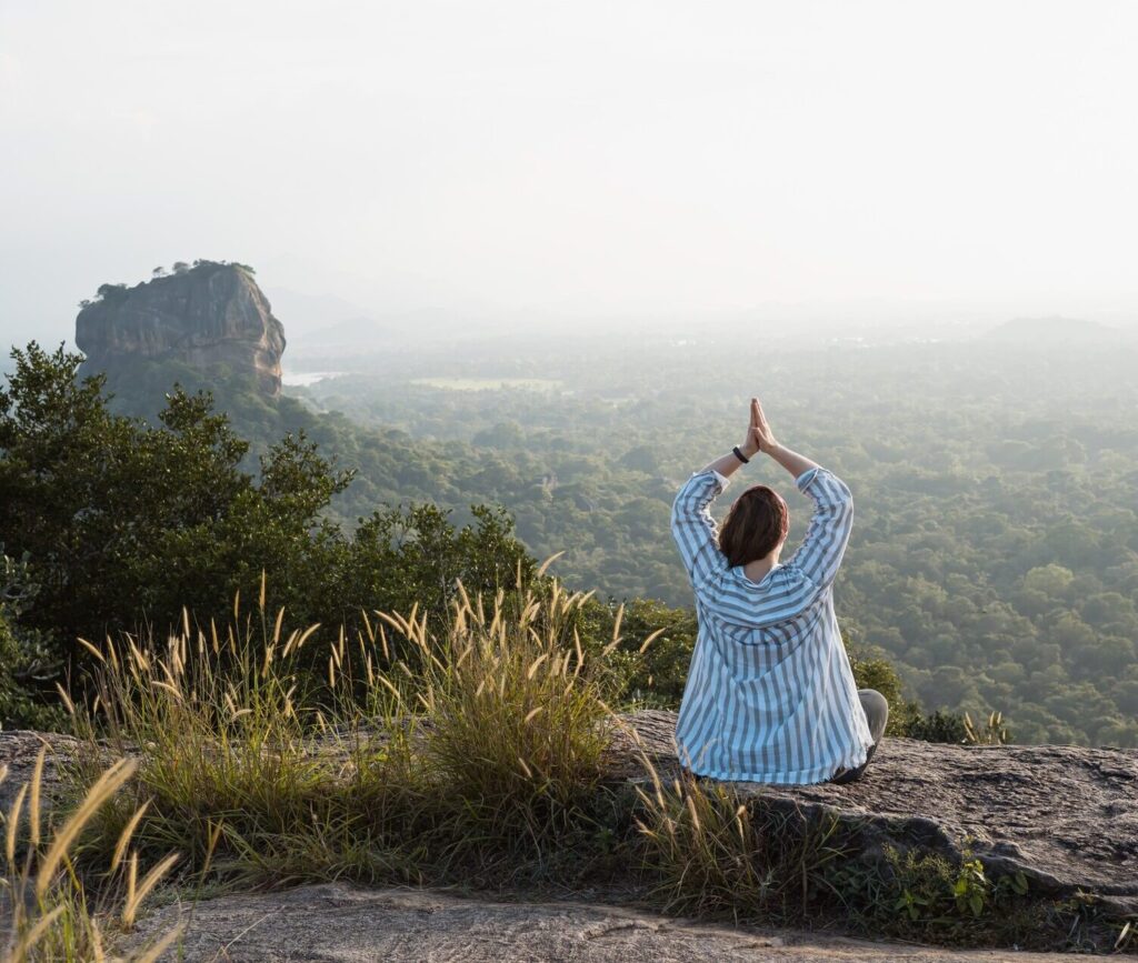 Woman doing yoga at sunset with scenic view Sigiriya in Sri Lanka